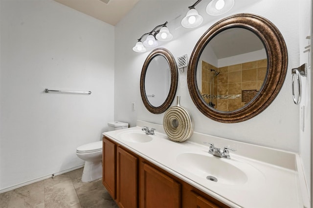 full bathroom with double vanity, toilet, a tile shower, and a sink