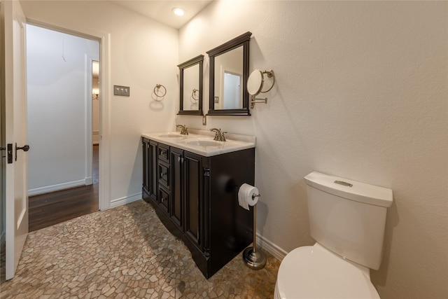 bathroom with toilet, baseboards, and a sink