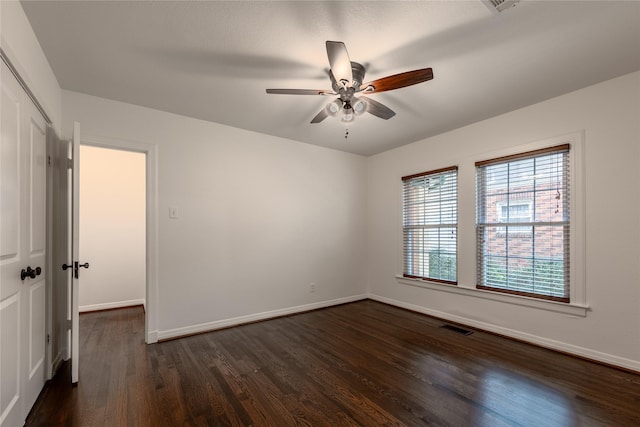 unfurnished bedroom featuring baseboards, visible vents, a ceiling fan, dark wood-type flooring, and a closet