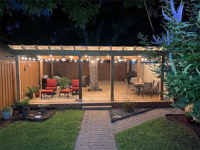 yard at twilight with a fenced backyard, a pergola, and a wooden deck