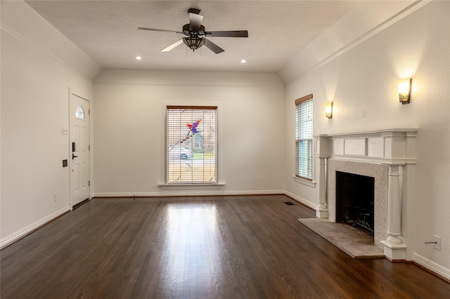 unfurnished living room featuring baseboards, lofted ceiling, ceiling fan, dark wood-type flooring, and a fireplace