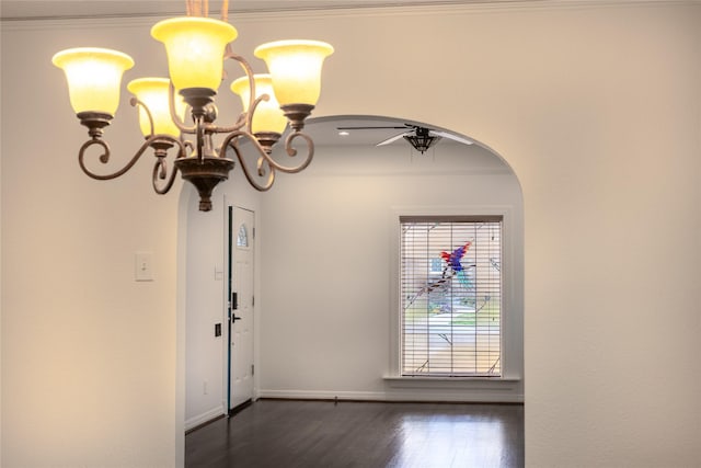 interior space with baseboards, arched walkways, dark wood finished floors, ornamental molding, and an inviting chandelier