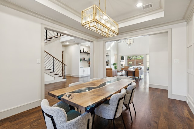 dining space featuring ornamental molding, a raised ceiling, dark wood-type flooring, and an inviting chandelier