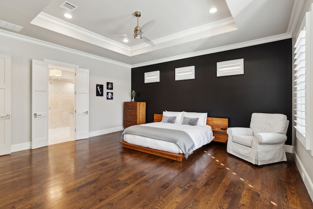 bedroom with visible vents, a raised ceiling, and wood finished floors