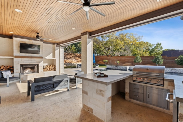 view of patio featuring an outdoor kitchen, a grill, a ceiling fan, fence, and an outdoor living space with a fireplace