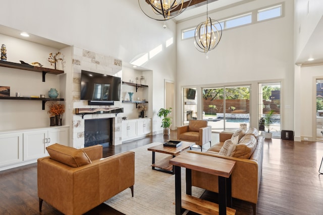 living area featuring baseboards, a fireplace, a chandelier, and wood finished floors