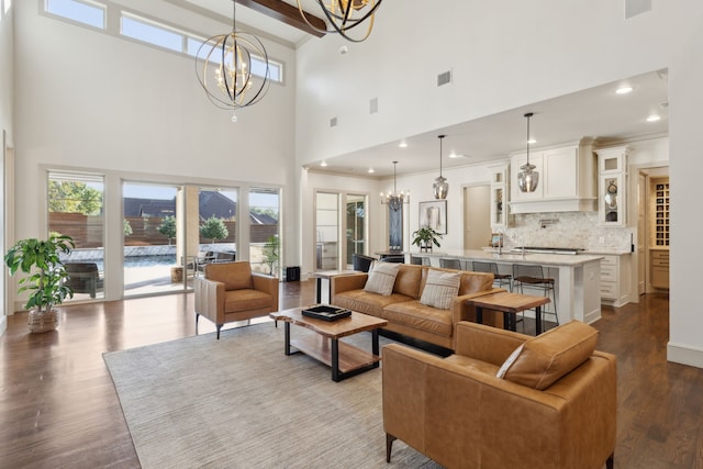 living area featuring ornamental molding, recessed lighting, wood finished floors, and a notable chandelier