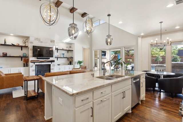 kitchen featuring dishwasher, dark wood-style flooring, an inviting chandelier, a fireplace, and a sink