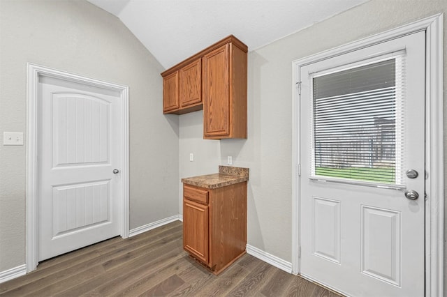 kitchen with lofted ceiling, dark wood-style floors, baseboards, and brown cabinetry