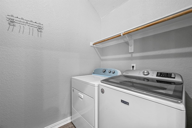 laundry room with washer and dryer, laundry area, and a textured wall