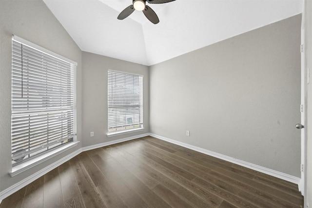 spare room with lofted ceiling, dark wood-style floors, ceiling fan, and baseboards