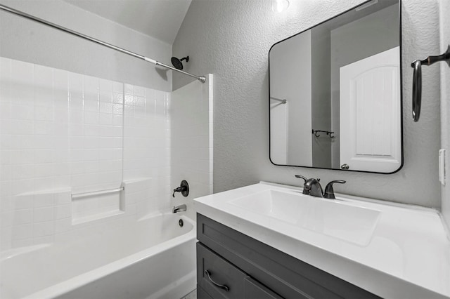 bathroom featuring shower / tub combination, vanity, and a textured wall