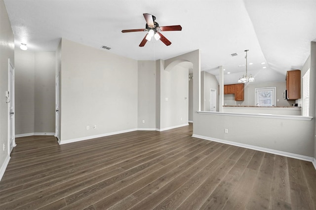 unfurnished living room with arched walkways, visible vents, dark wood-style flooring, vaulted ceiling, and ceiling fan with notable chandelier