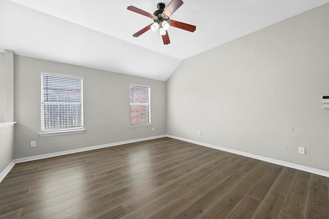 unfurnished room featuring a ceiling fan, vaulted ceiling, dark wood finished floors, and baseboards