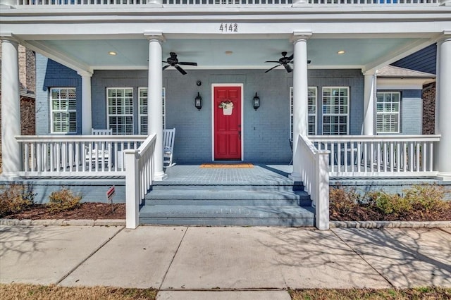 property entrance with covered porch, brick siding, and a ceiling fan