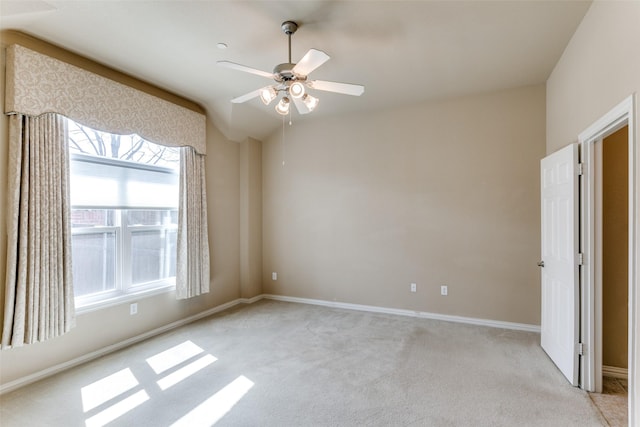 unfurnished bedroom featuring light carpet, ceiling fan, lofted ceiling, and baseboards