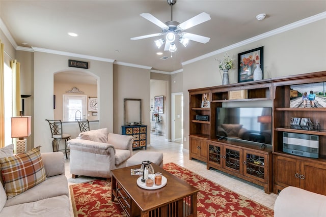 living room with light tile patterned floors, visible vents, arched walkways, a ceiling fan, and crown molding