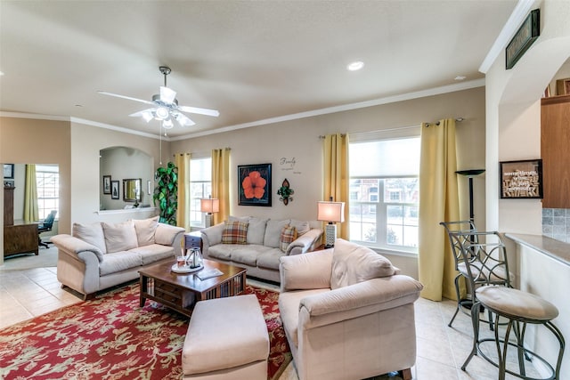 living area featuring light tile patterned floors, ornamental molding, and a wealth of natural light