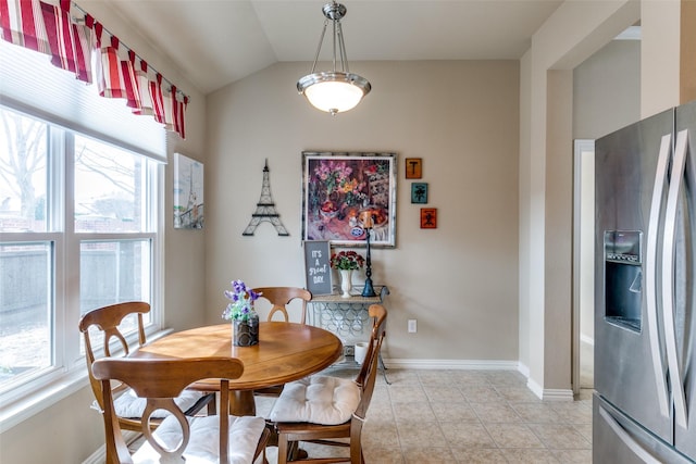 dining area with lofted ceiling, baseboards, and light tile patterned floors