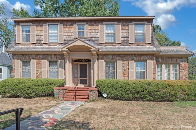 view of front facade featuring a front yard and stone siding