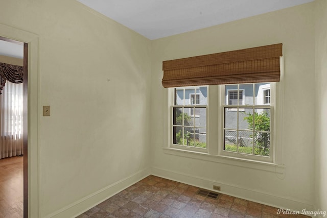 empty room featuring baseboards and visible vents