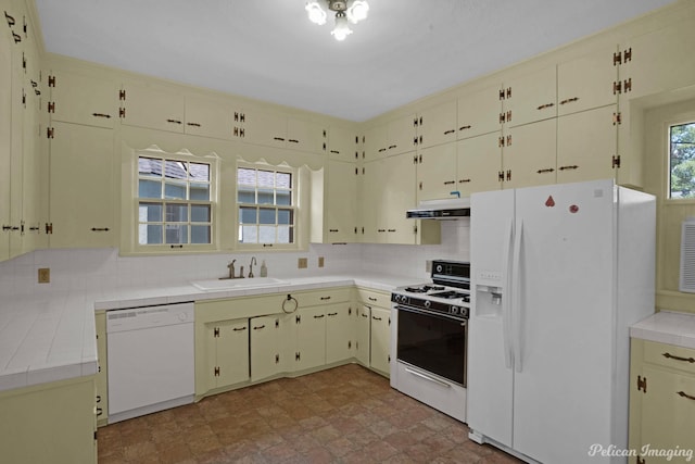 kitchen featuring tile countertops, white appliances, a sink, cream cabinetry, and backsplash