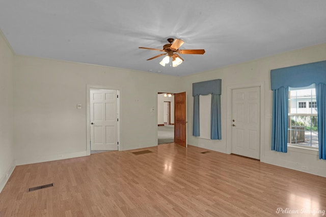 empty room with a ceiling fan, visible vents, and wood finished floors