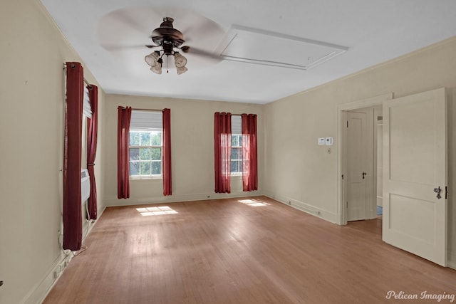 empty room featuring light wood-type flooring, a ceiling fan, and baseboards