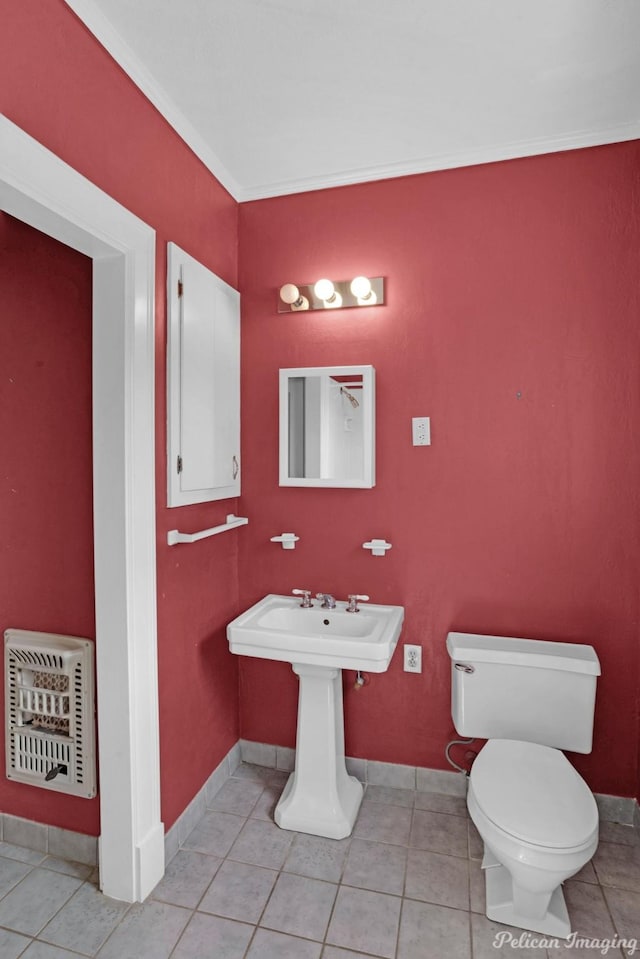 bathroom featuring heating unit, toilet, and tile patterned floors