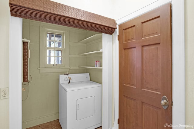 clothes washing area with laundry area, washer / clothes dryer, and baseboards