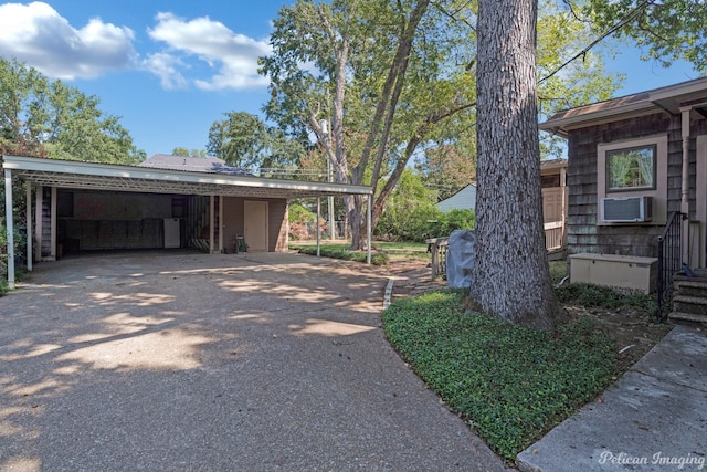 view of side of home featuring driveway, a carport, and cooling unit