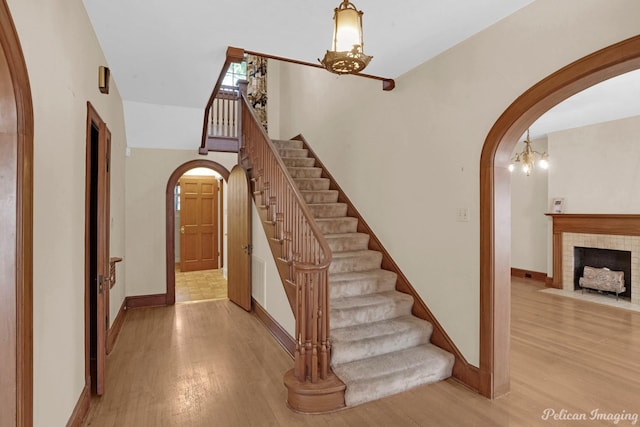 entrance foyer featuring arched walkways, wood finished floors, and baseboards