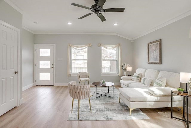 living area featuring crown molding, lofted ceiling, a ceiling fan, light wood-type flooring, and baseboards