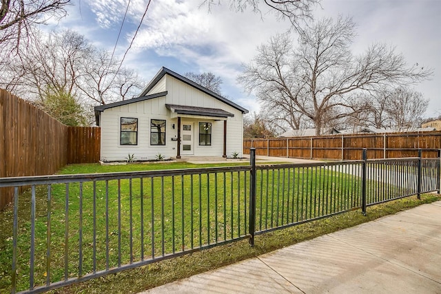 view of front of home featuring a fenced backyard, a front lawn, and board and batten siding