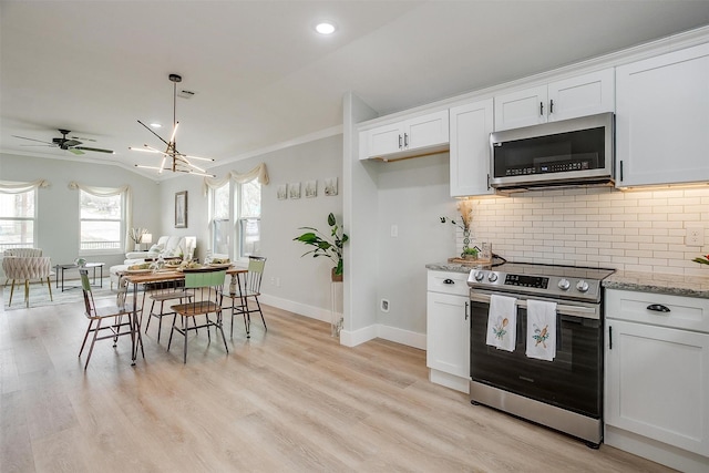 kitchen with light wood-style flooring, appliances with stainless steel finishes, white cabinets, and backsplash