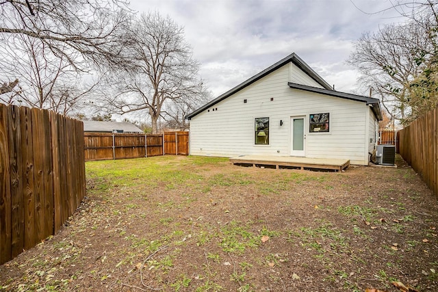 rear view of house with central AC, a fenced backyard, a yard, and a deck