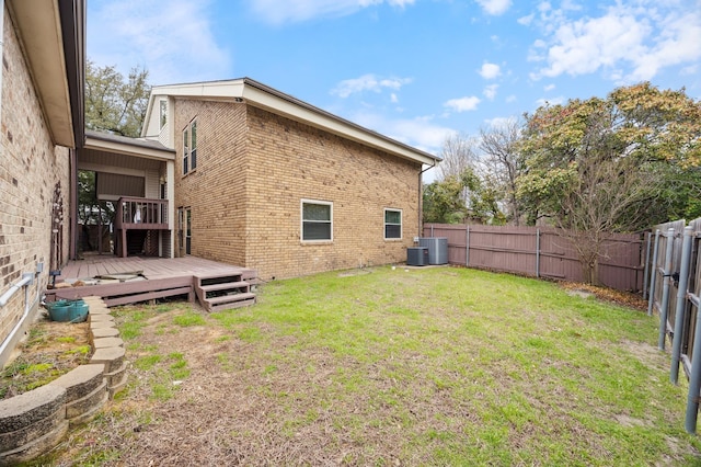 view of yard with a fenced backyard, a deck, and cooling unit