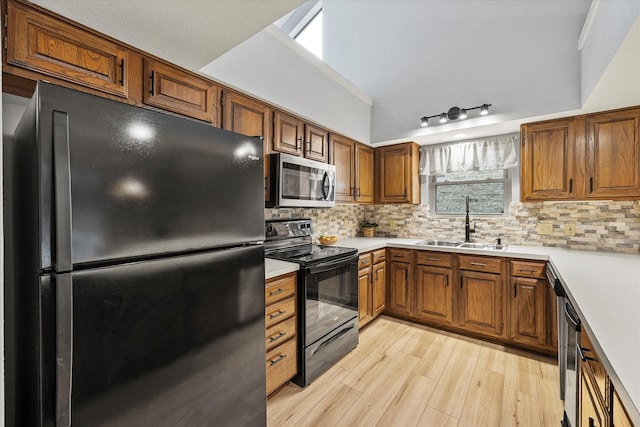 kitchen with black appliances, brown cabinetry, a sink, and light countertops