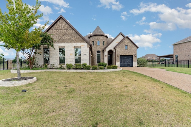 french country home featuring a front yard, brick siding, fence, and driveway