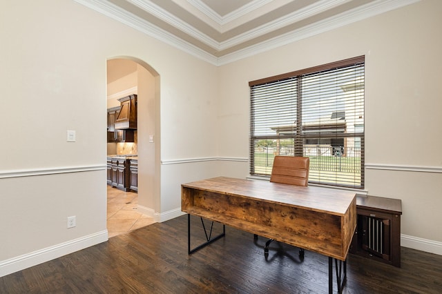 office space featuring arched walkways, ornamental molding, wood finished floors, and baseboards