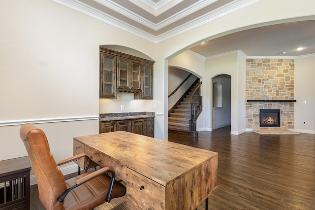 interior space with crown molding, baseboards, dark wood-style flooring, and a stone fireplace