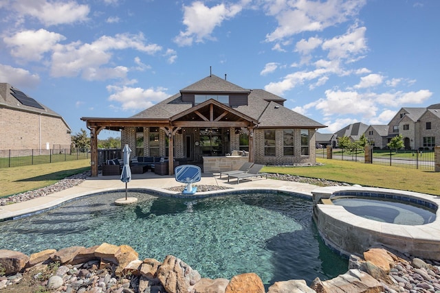 view of pool with a pool with connected hot tub, a lawn, an outdoor hangout area, a patio area, and a fenced backyard