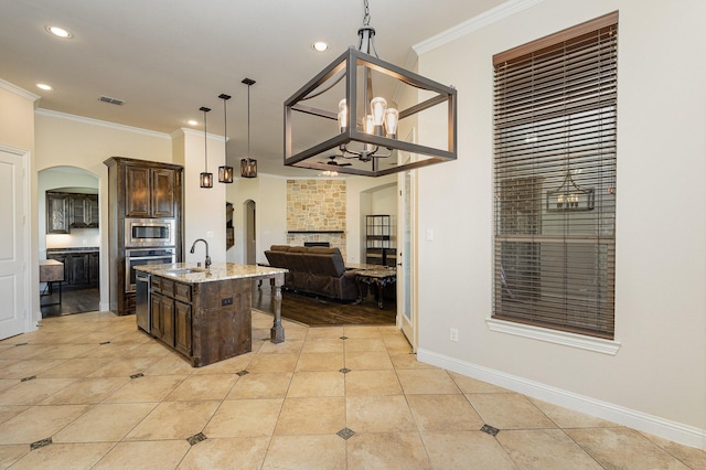 kitchen featuring arched walkways, a sink, and dark brown cabinetry