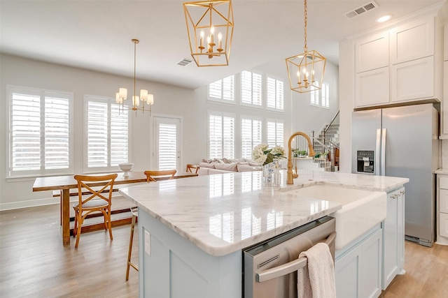 kitchen featuring light wood finished floors, visible vents, stainless steel appliances, and a notable chandelier