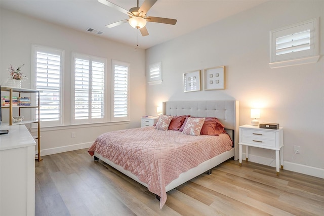 bedroom with ceiling fan, light wood-type flooring, visible vents, and baseboards