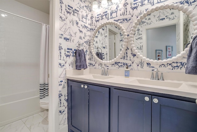 full bathroom featuring marble finish floor, double vanity, a sink, and wallpapered walls