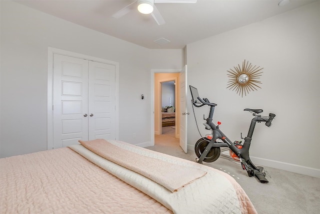 bedroom with light carpet, ceiling fan, baseboards, and a closet