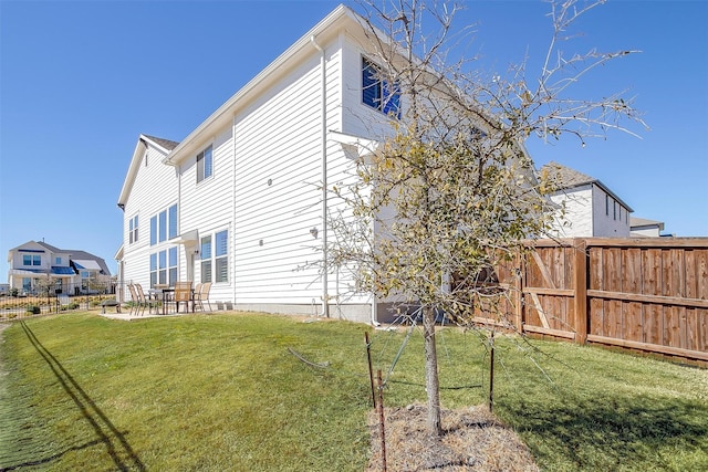 rear view of property with a yard, a patio, and fence