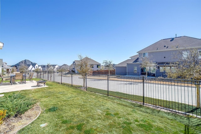 view of yard with a residential view, a fenced backyard, and a patio