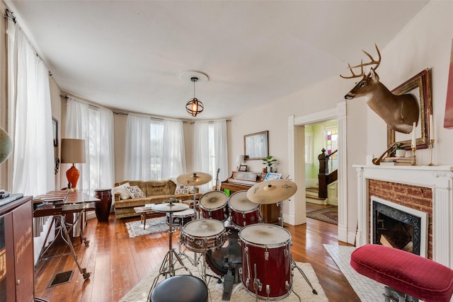 living area with hardwood / wood-style floors, a fireplace, and visible vents